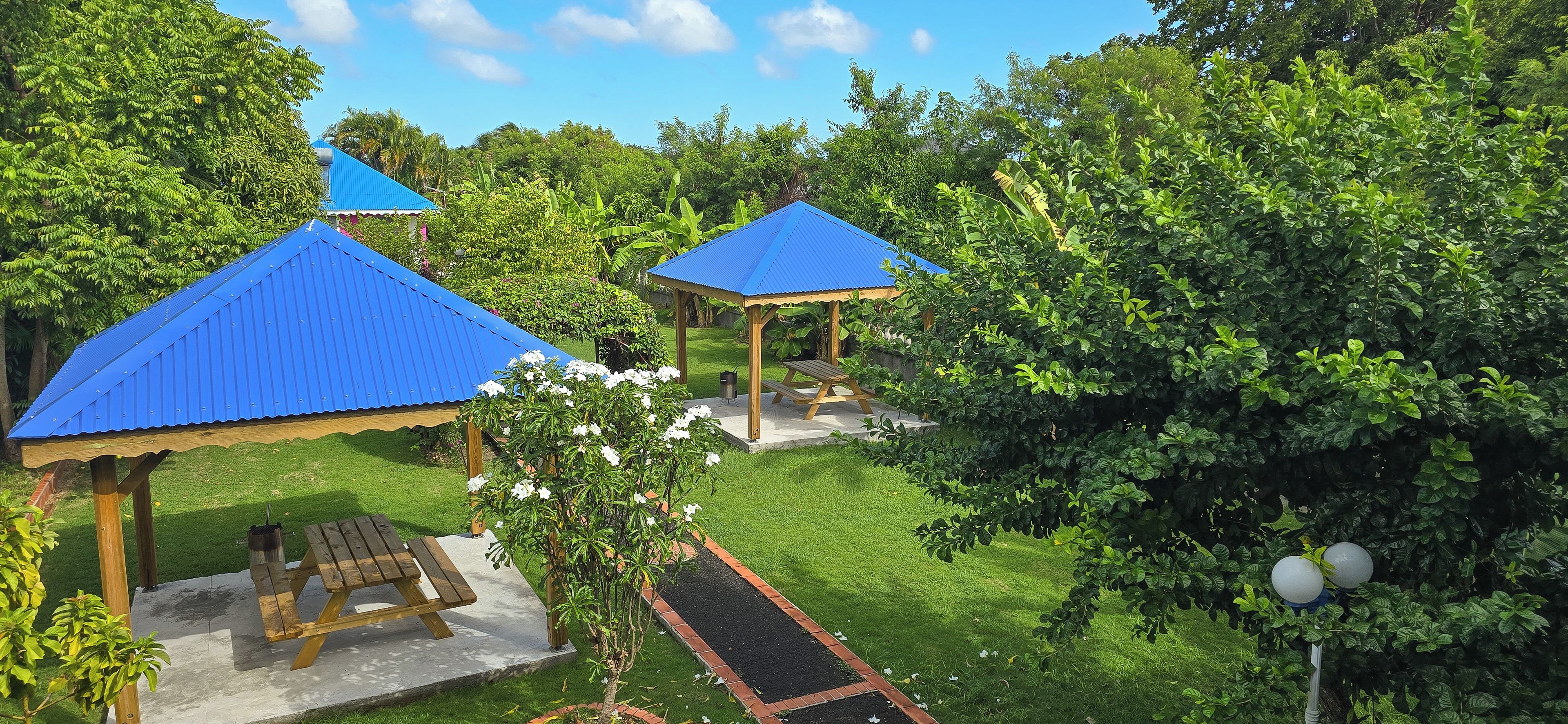 A gazebo with a blue roof, a picnic table, and a well-maintained lawn.