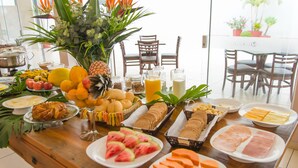 A breakfast buffet with various fruits, pastries, and beverages. - Lazuli Hotel (Itatiba)