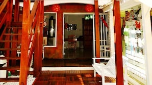 Un restaurante llamado 'borakay pousada' con fachada de madera, un letrero y una escalera que conduce a un nivel superior.