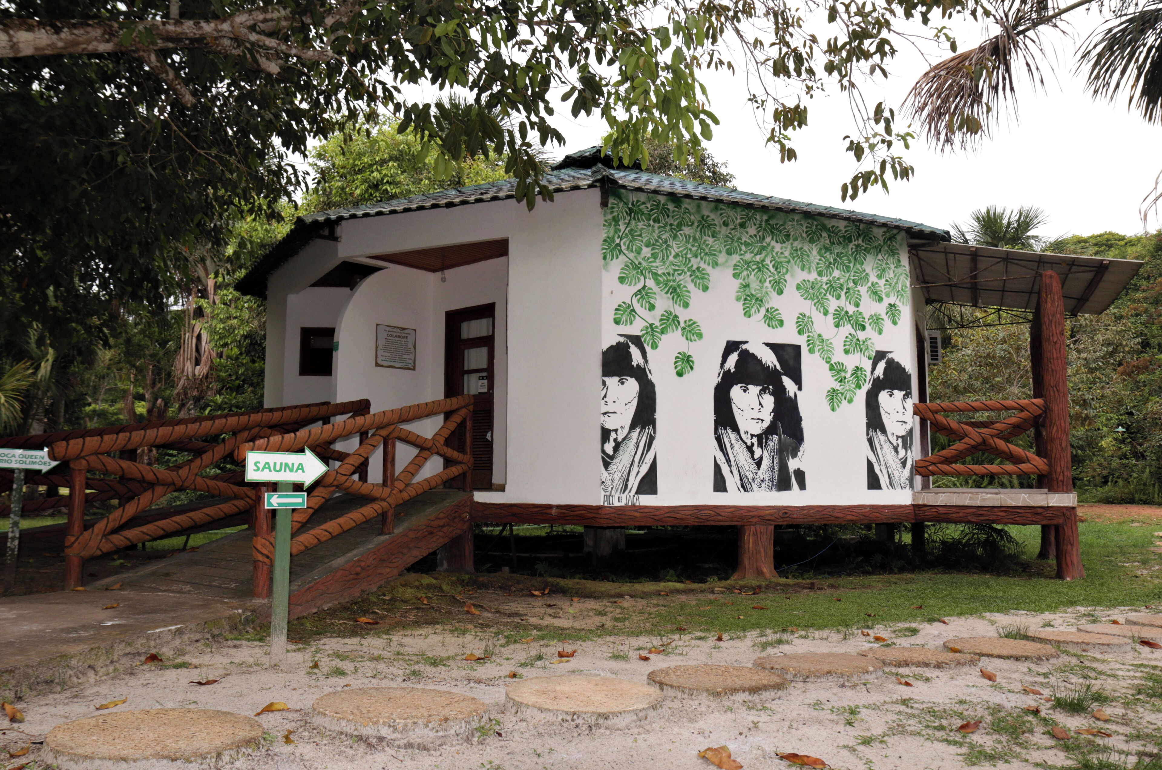 A small building with a sign indicating 'SAUNA' and a mural with portraits.