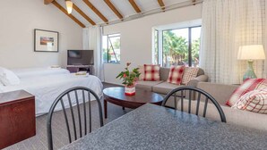 A hotel room with a bed, sofa, dining table, and TV. - Anzac Court Motel (Auckland)