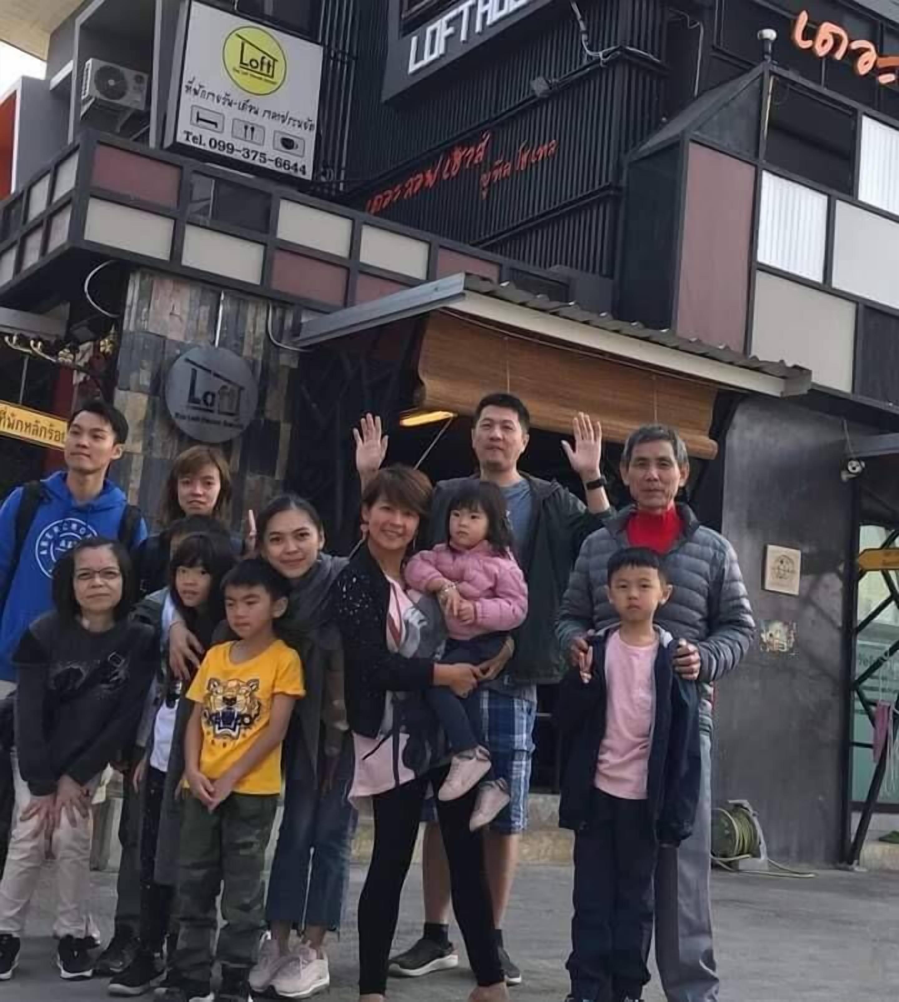 Een groep mensen staat voor een gebouw, met een bordje dat 'Loft' zegt.