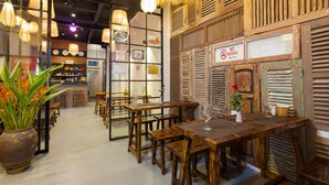 A restaurant with wooden tables and chairs, a bar area, and a 'No Smoking' sign. - Luxury Backpackers (Hanoi)