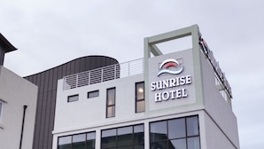 Ein modernes Hotelgebäude mit einer gut sichtbaren Schilder für das Sunrise Hotel.
