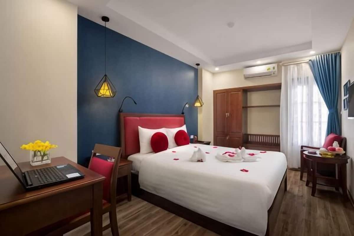 Une chambre d’hôtel équipée d’un lit, d’un bureau, d’une chaise et d’une armoire.