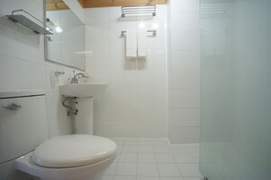 Un baño con inodoro, lavamanos y ducha.