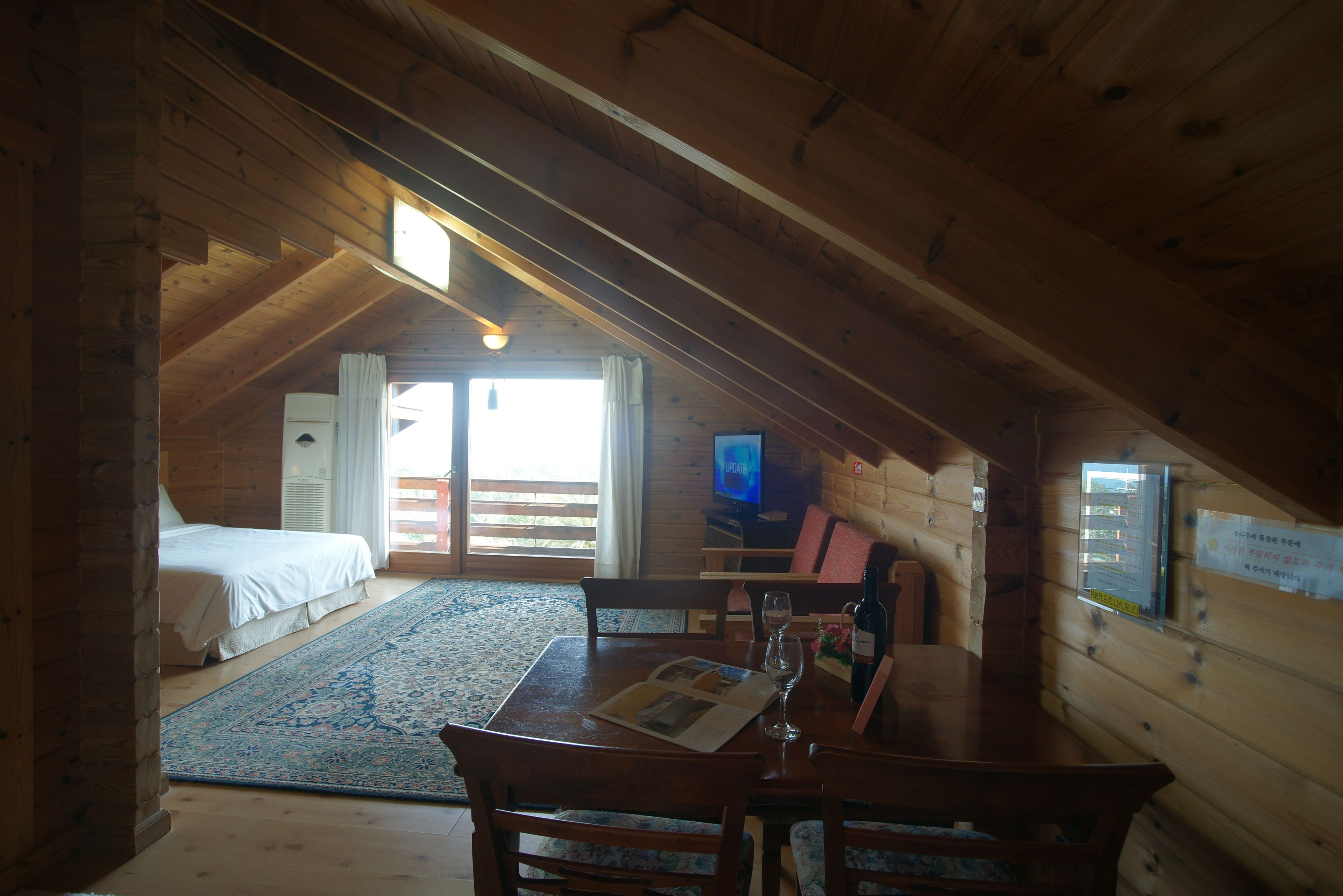 Un accogliente chalet in legno con camera da letto in soppalco, zona pranzo e televisore.