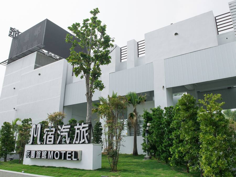 A modern building with a sign for a hotel named "Flower Garden Motel".