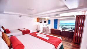 A hotel room with two beds, a kitchenette, a balcony with a view, and a dining area. - Dreamwave Hotel Puerto Galera (Puerto Galera)