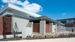 A modern building with a flat roof, large windows, and a mix of brick and concrete walls. - Loxton Courthouse Apartments (Loxton)