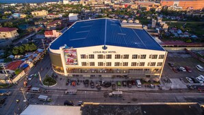 Un hotel con techo plano, paneles solares y un gran cartel luminoso.