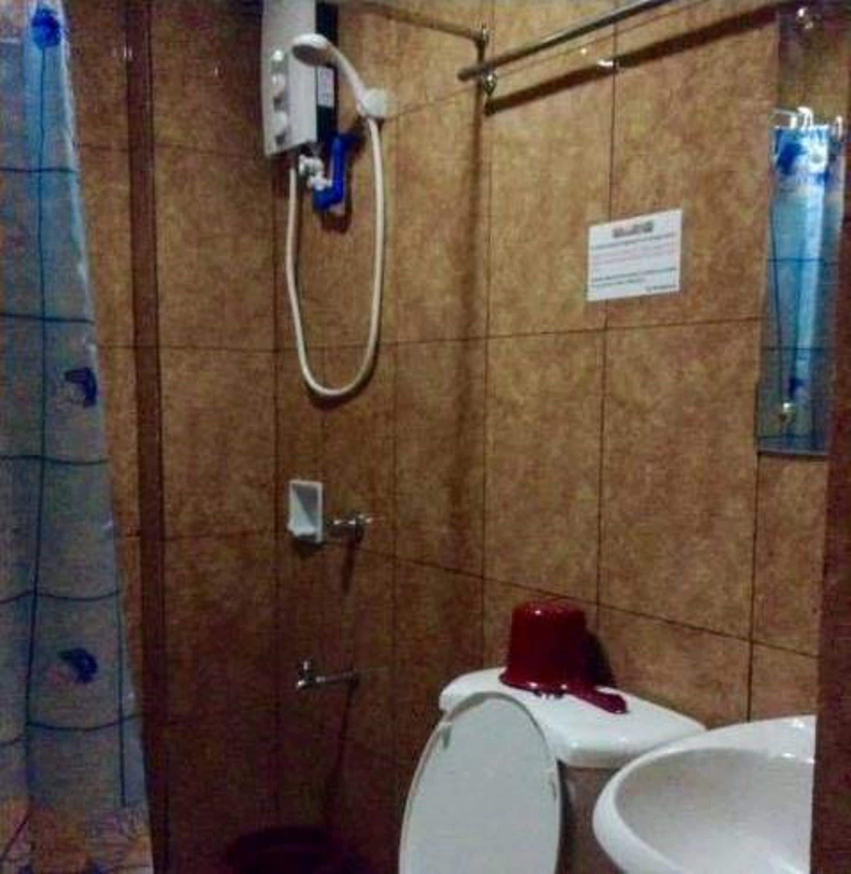 A bathroom with a shower, toilet, and sink.
