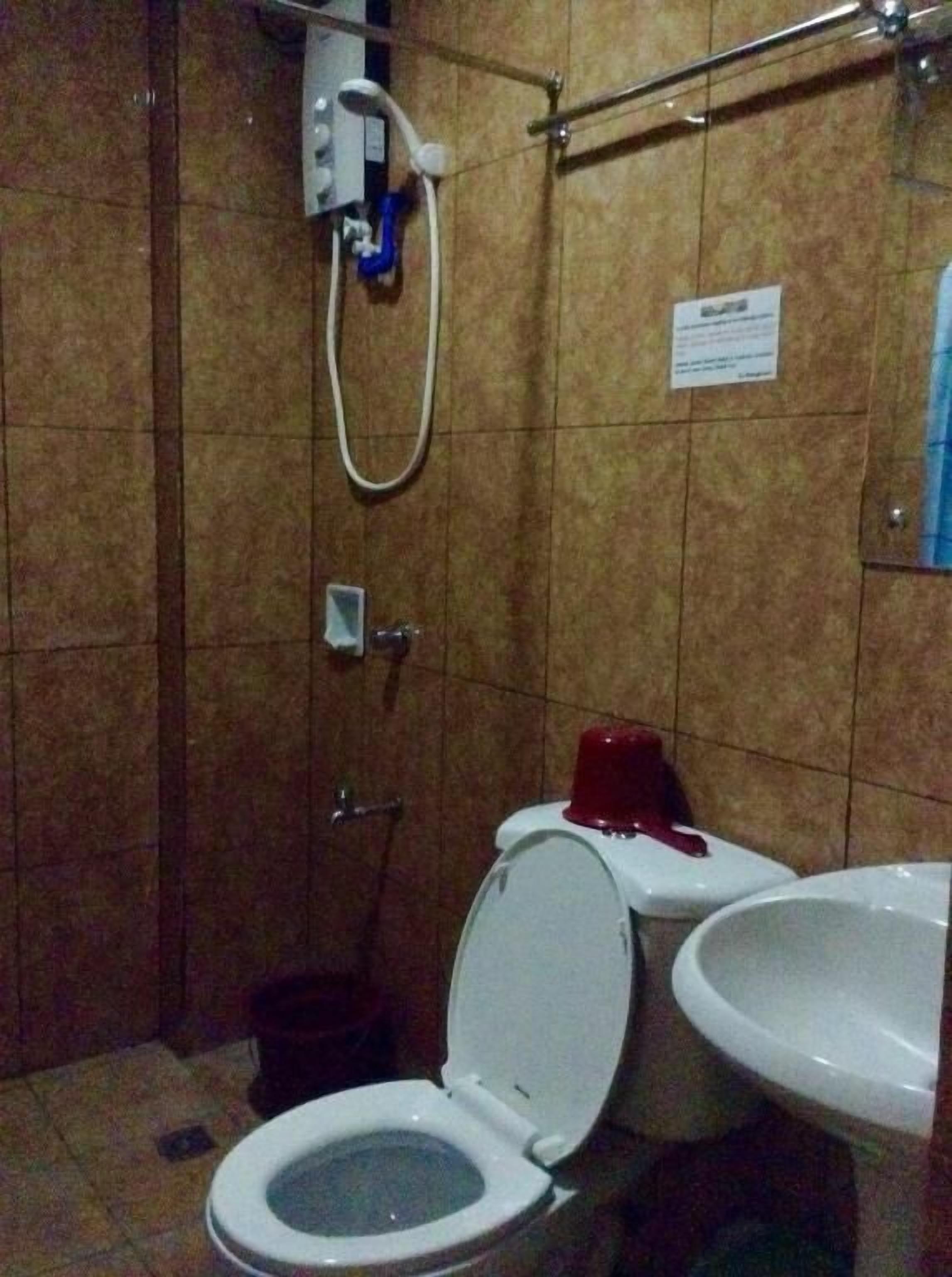 A bathroom with a toilet, a sink, and a shower.