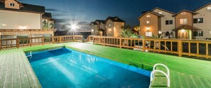A swimming pool with a wooden deck and a wooden fence. - Red Windmill Pension (Jeju City)