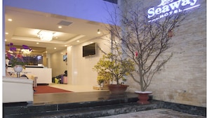 Exterior del Hotel Seaway con un diseño moderno, una zona de recepción y plantas en macetas.