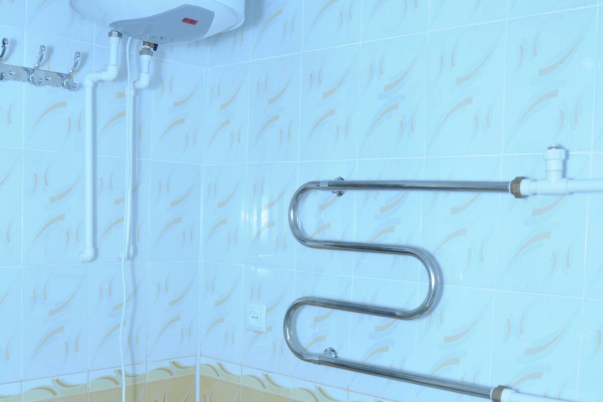 Une salle de bain équipée de toilettes, d’un bidet et d’un chauffe-eau.