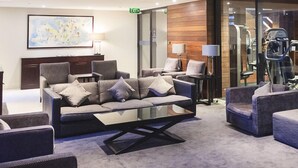 A modern lounge area with a sofa set, armchairs, and a glass coffee table. - Mono Apartments on Freshwater (Southbank)