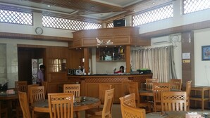 Un vaste espace dédié à la salle à manger, avec des meubles en bois et un bar central.