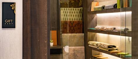 A gift shop with shelves of patterned textiles and a sign reading "GIFT SHOP".