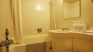 A bathroom with a bathtub, a sink, a mirror, and toiletries.