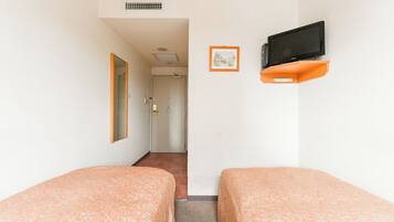 A hotel room with two beds, a television on an orange stand, a framed picture on the wall, and a door leading to a bathroom.
