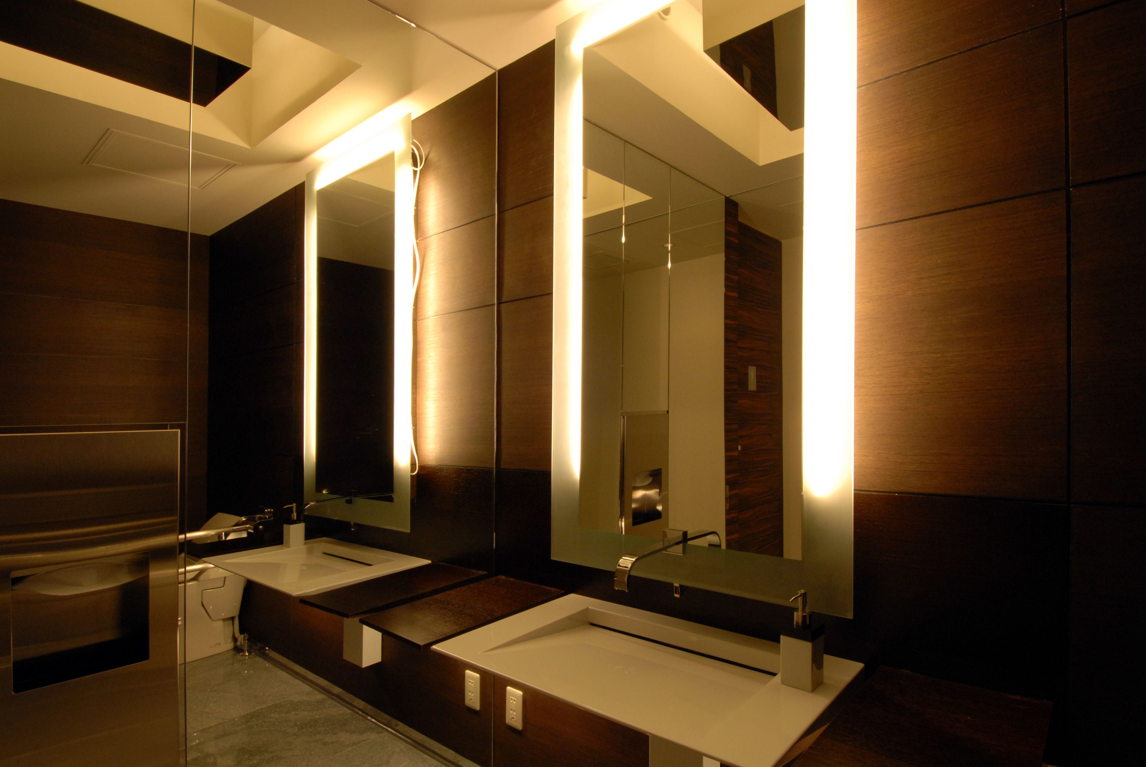 A modern bathroom with two sinks, large mirrors, and a shower.