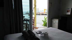 A hotel room with a bed, a pair of shoes, a remote control, and a roll of toilet paper. - Sunrise Villas Seaview (Rayong)