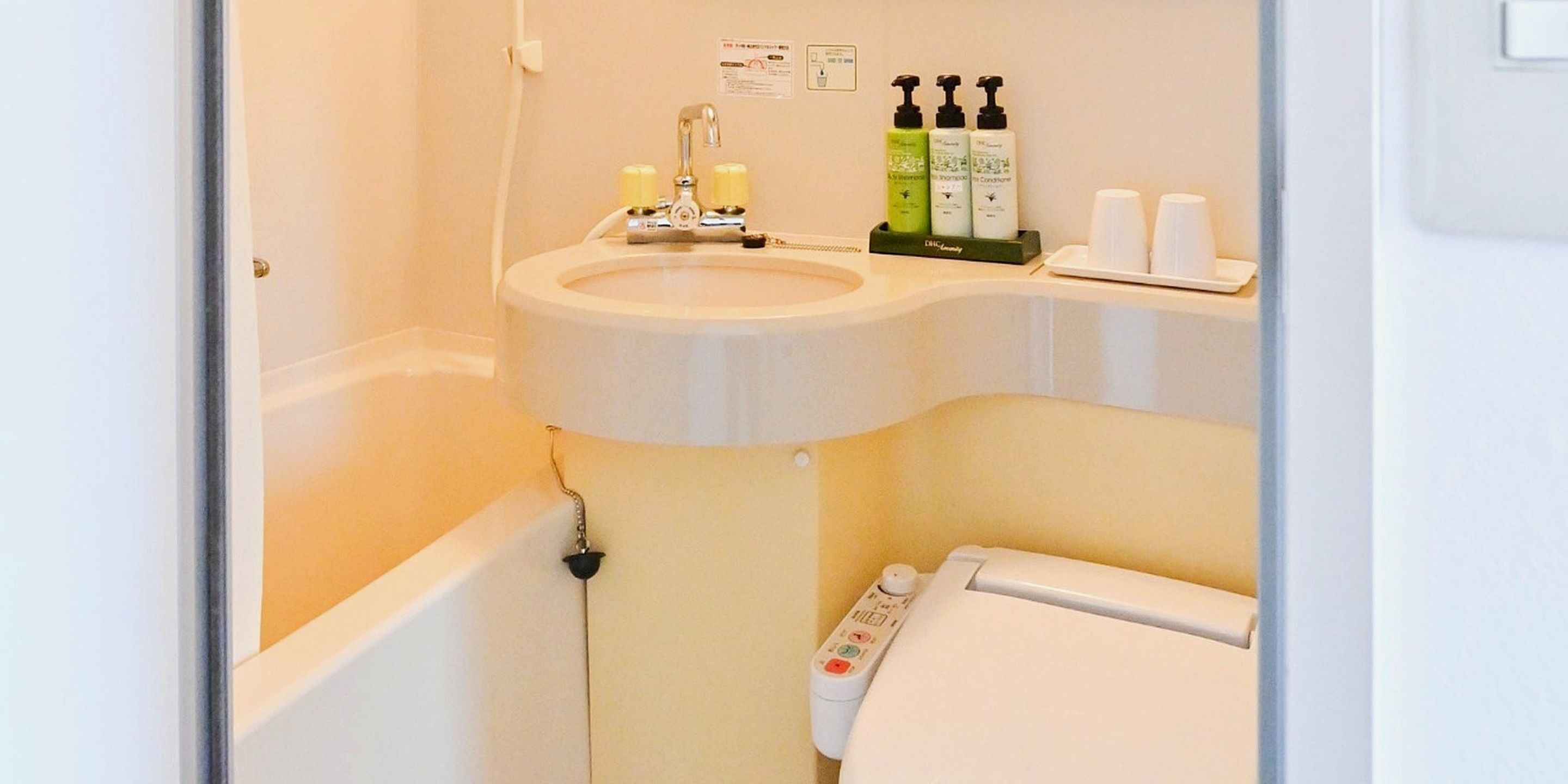 A bathroom with a sink, toilet, and a hand sanitizer dispenser.