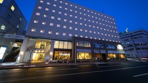 A modern hotel with a large number of rooms, a central entrance, and a visible staircase. - Kotoni Green Hotel (Sapporo)