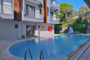 Piscine extérieure, parasols de plage, chaises longues