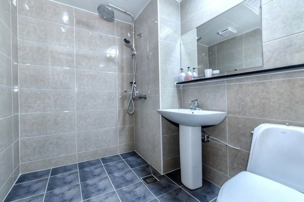 A bathroom with a shower, sink, and toilet.