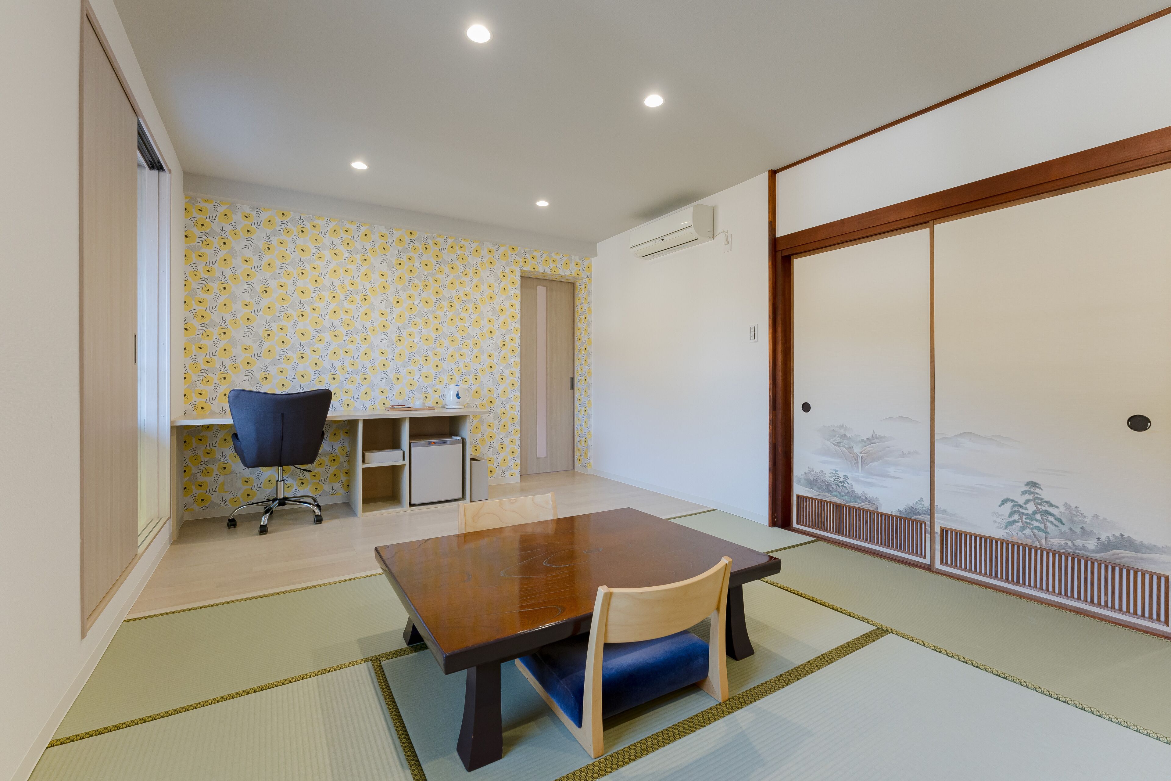 Ein traditioneller japanischer Raum mit Tatami-Bodenbelag, einem niedrigen Holztisch und einem Shoji-Bildschirm.