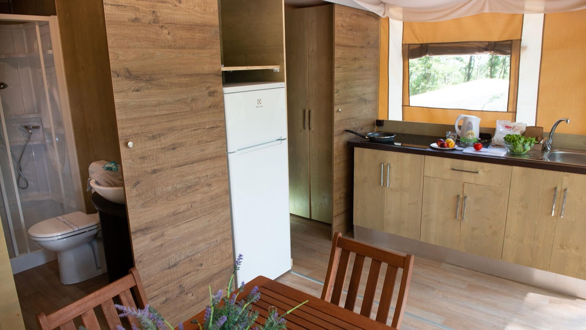 A compact kitchen with wooden cabinets and a window.