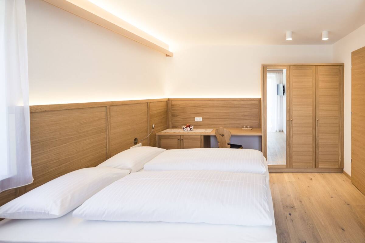 Een slaapkamer met een bed, nachtkastje en een kledingkast.