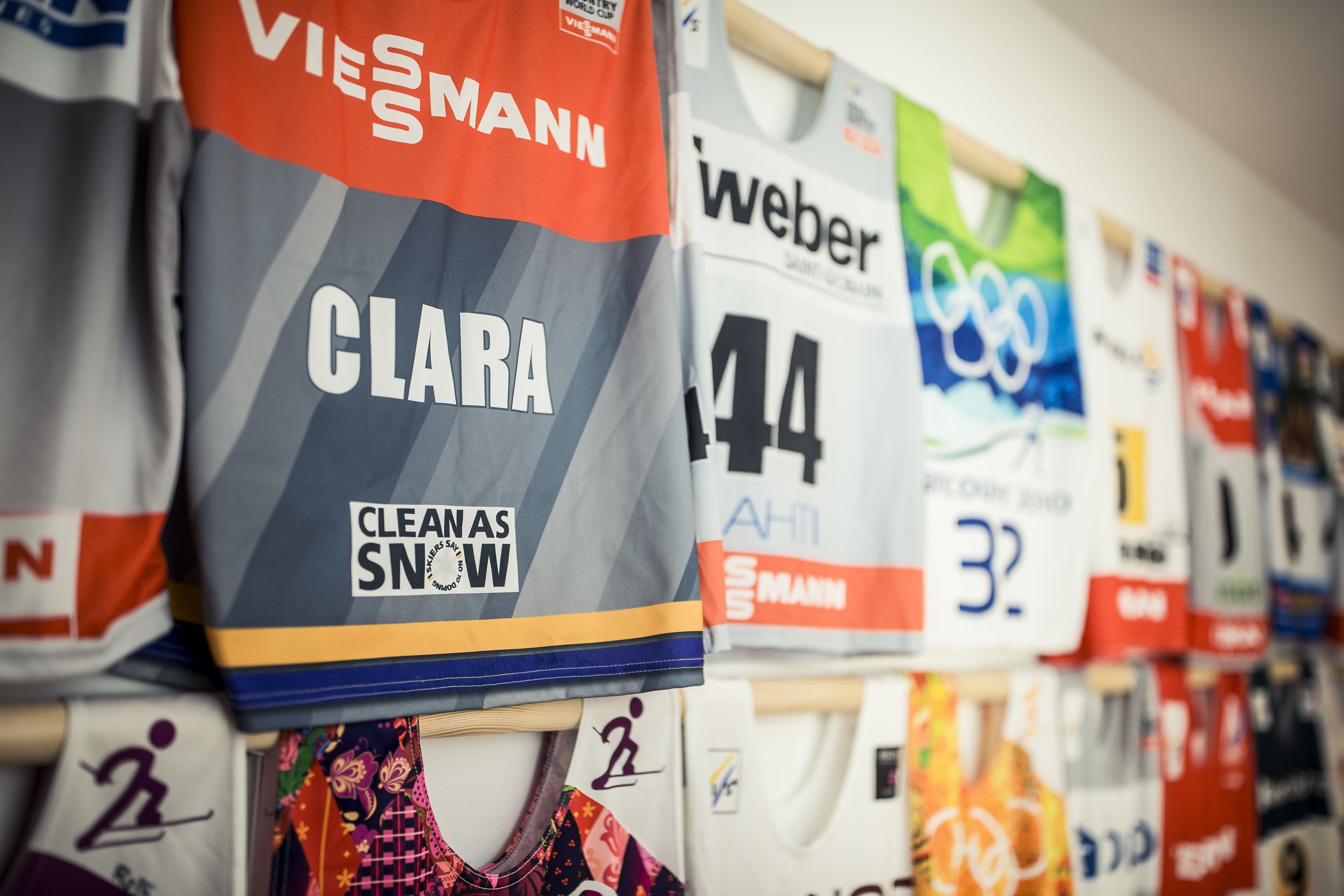 A wall with various sports jerseys hanging.