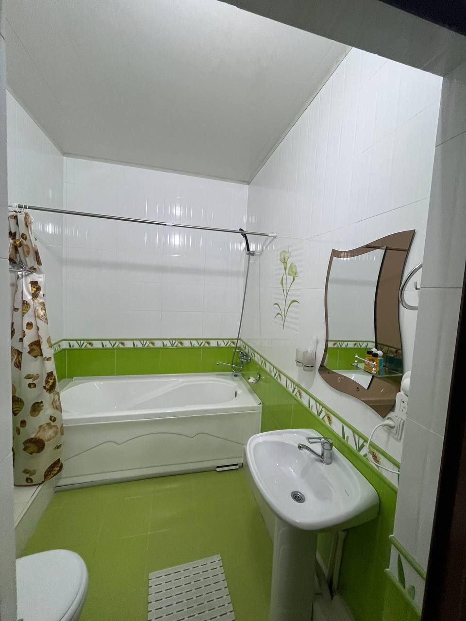 Ein Badezimmer mit Badewanne, Waschbecken, Toilette und Duschvorhang.