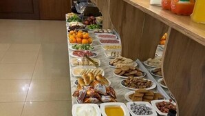 A buffet table with various food items and condiments.
