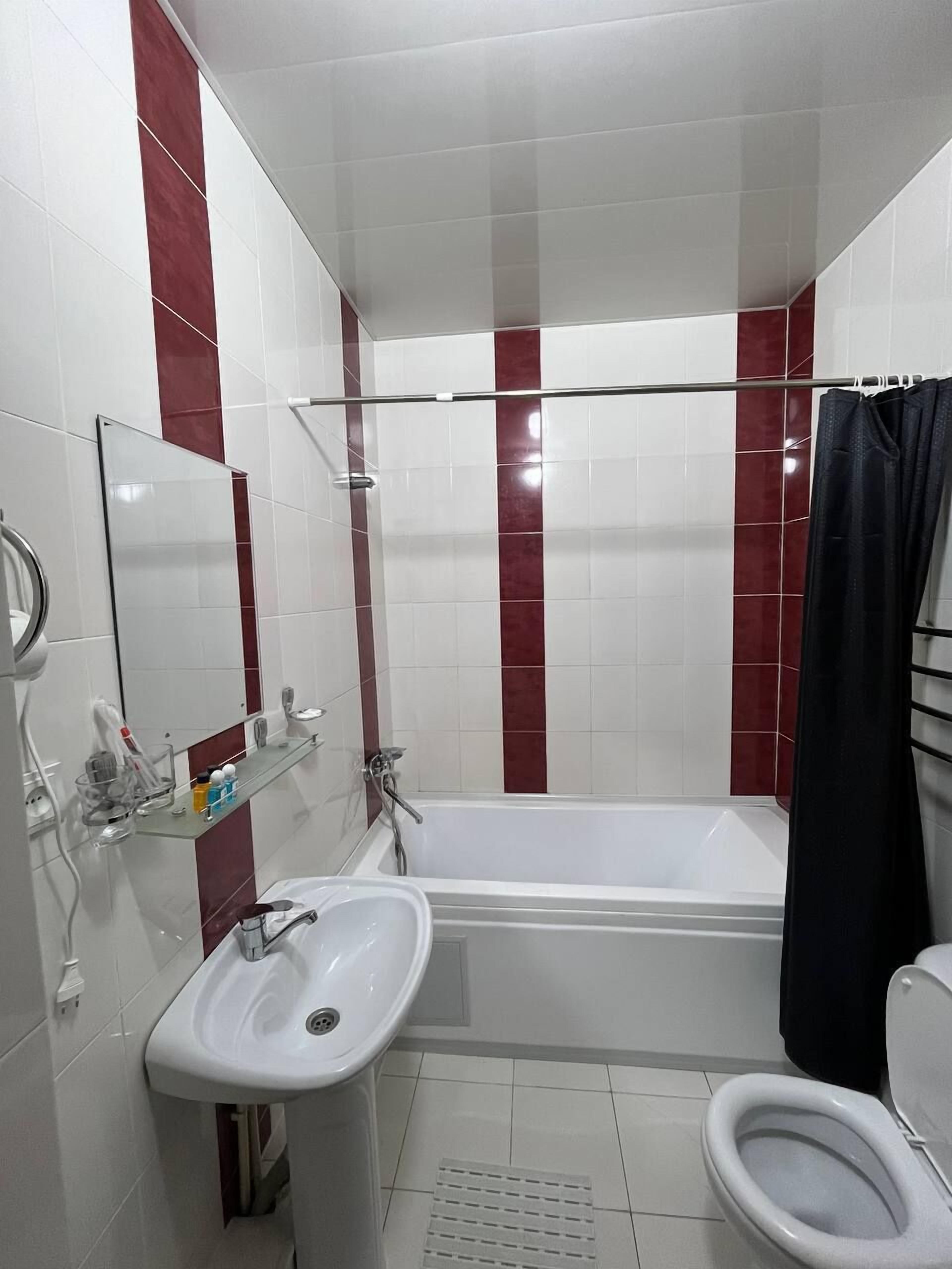 Une salle de bain avec une baignoire, un lavabo, des toilettes et un miroir.