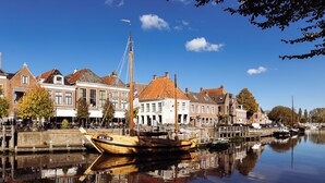 A canal with traditional buildings and a wooden boat docked at the pier.