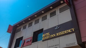 A building with a sign for Hotel Guest Inn Residency, including its address and a nearby OYO hotel. - Hotel Guest Inn Residency (Mumbai)
