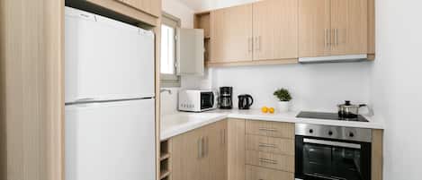 A modern kitchen with wooden cabinets, a built-in oven, a microwave, and a coffee maker.