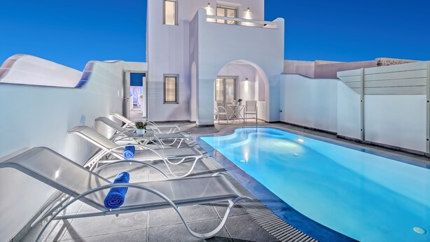 Ein moderner Poolbereich mit Liegestühlen und blauem Himmel.