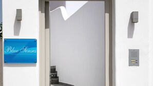 Ein weißes Gebäude mit einem blauen Schild, auf dem 