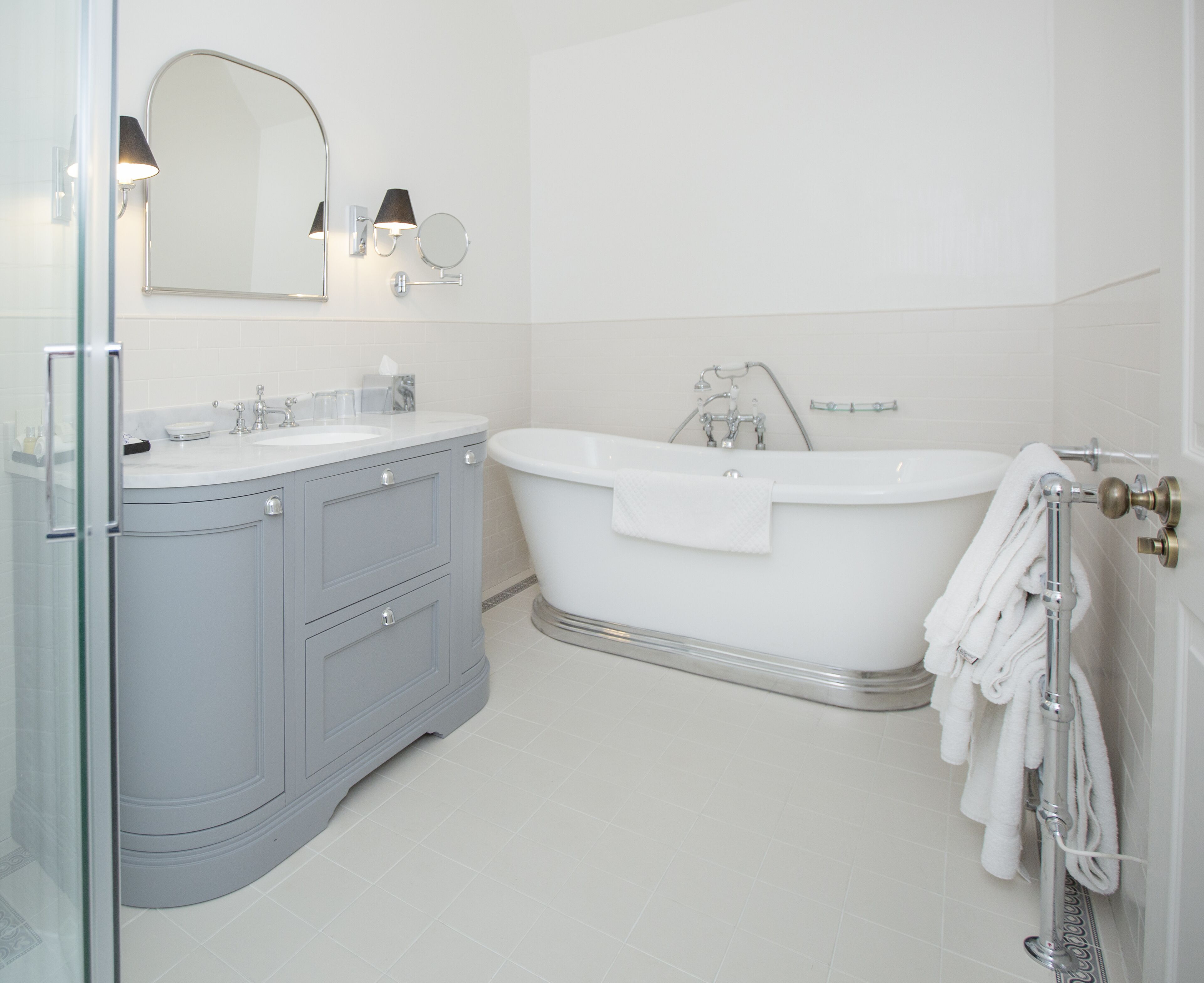 A modern bathroom with a freestanding bathtub, a vanity with a mirror, and a glass shower enclosure.