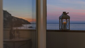Un balcón con vista al mar y al atardecer.