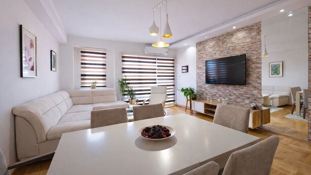 A modern living room with a sofa, dining table, and TV. - Urban Serviced Apartments (Skopje)