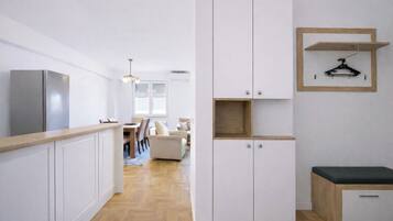 Una cocina moderna con armarios blancos, encimera de madera y un banco empotrado.