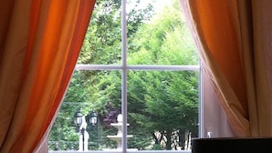 A window with orange curtains, a lamp, and a mirror. - Chateau du Mesnil (La Vieille-Lyre)