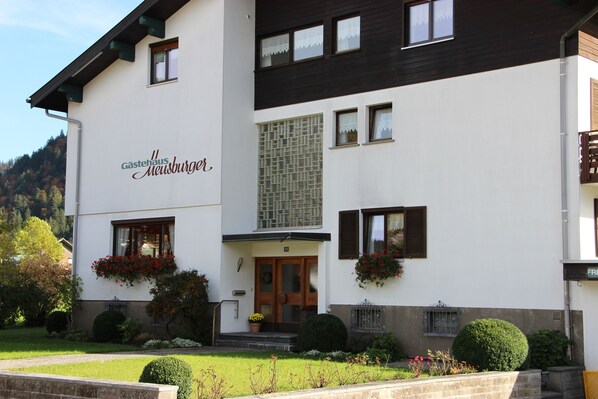 A two-story building with a white facade and a sign reading "Gästehaus Meusburger." - Gästehaus Meusburger (Bezau)