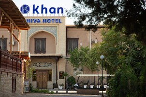 Un hotel con un letrero llamativo, una entrada tradicional y un área de estacionamiento con un carrito de golf.